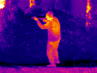 Ironbow thermal camera image of a man holding a rifle and aiming